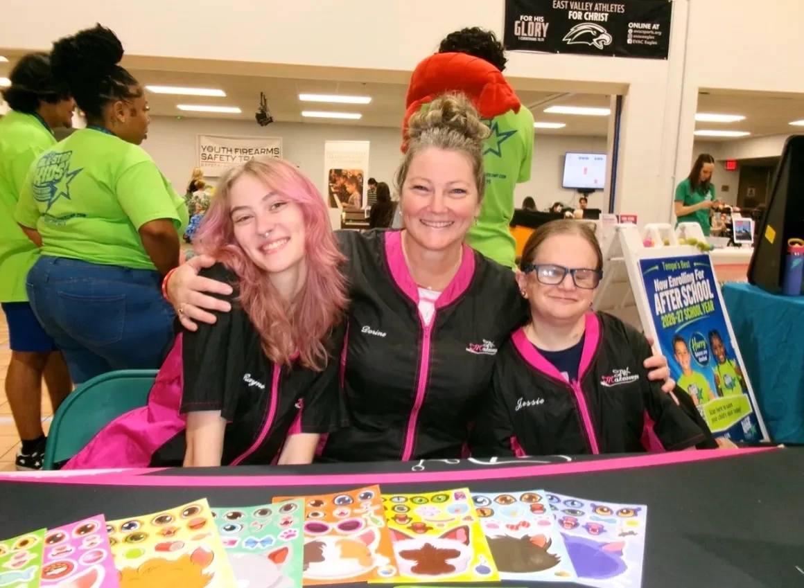Pet Makeovers team members Rayne, Dorine, and Jessie smiling at a community event